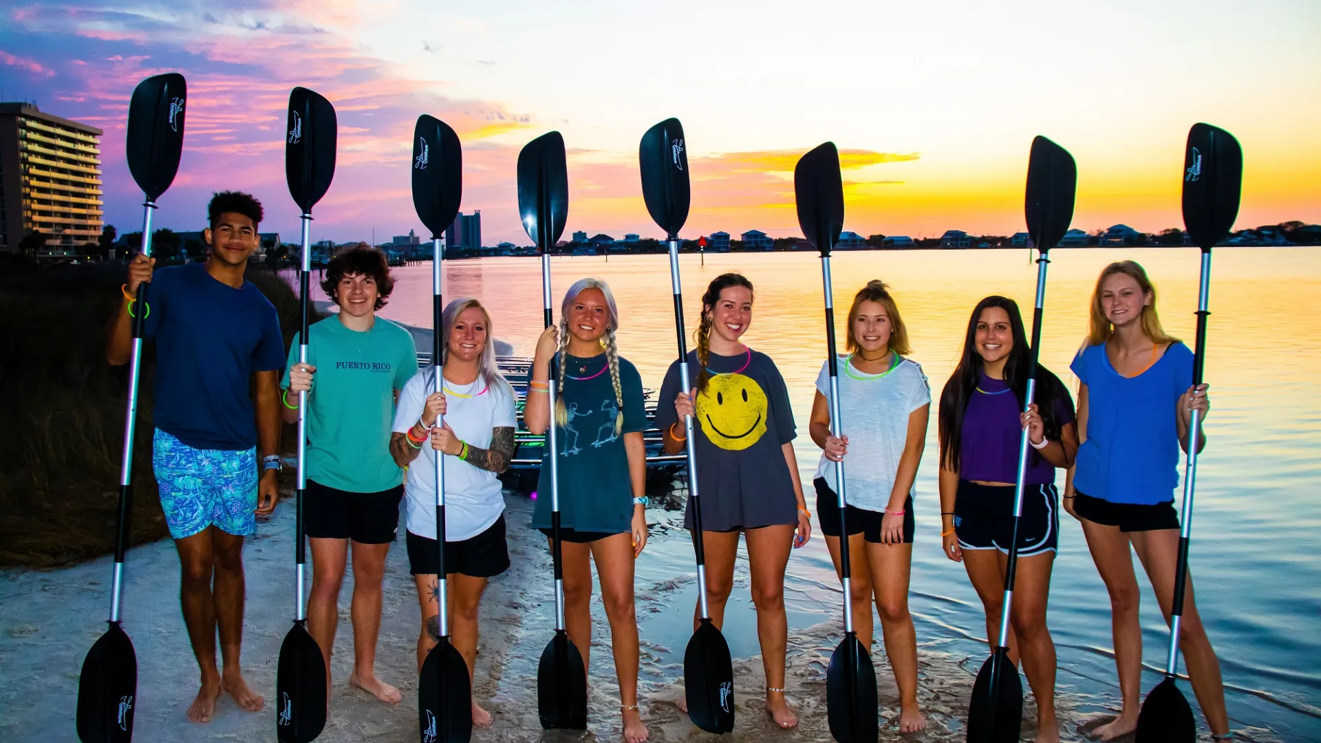 a group of people standing on a beach posing for the camera