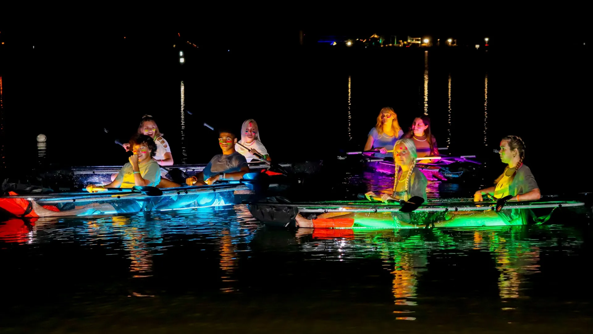 a group of men riding on the back of a boat in the water