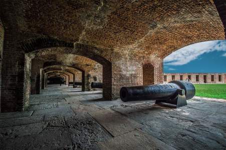 a stone building that has a bench in front of a brick wall